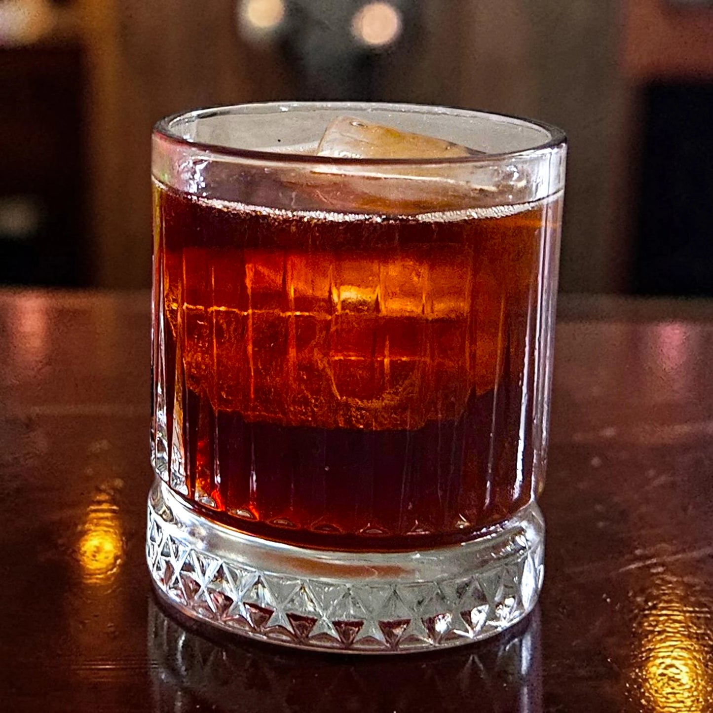 A glass of Strange Cane Fiery Cherry spiced rum on ice topped with cola