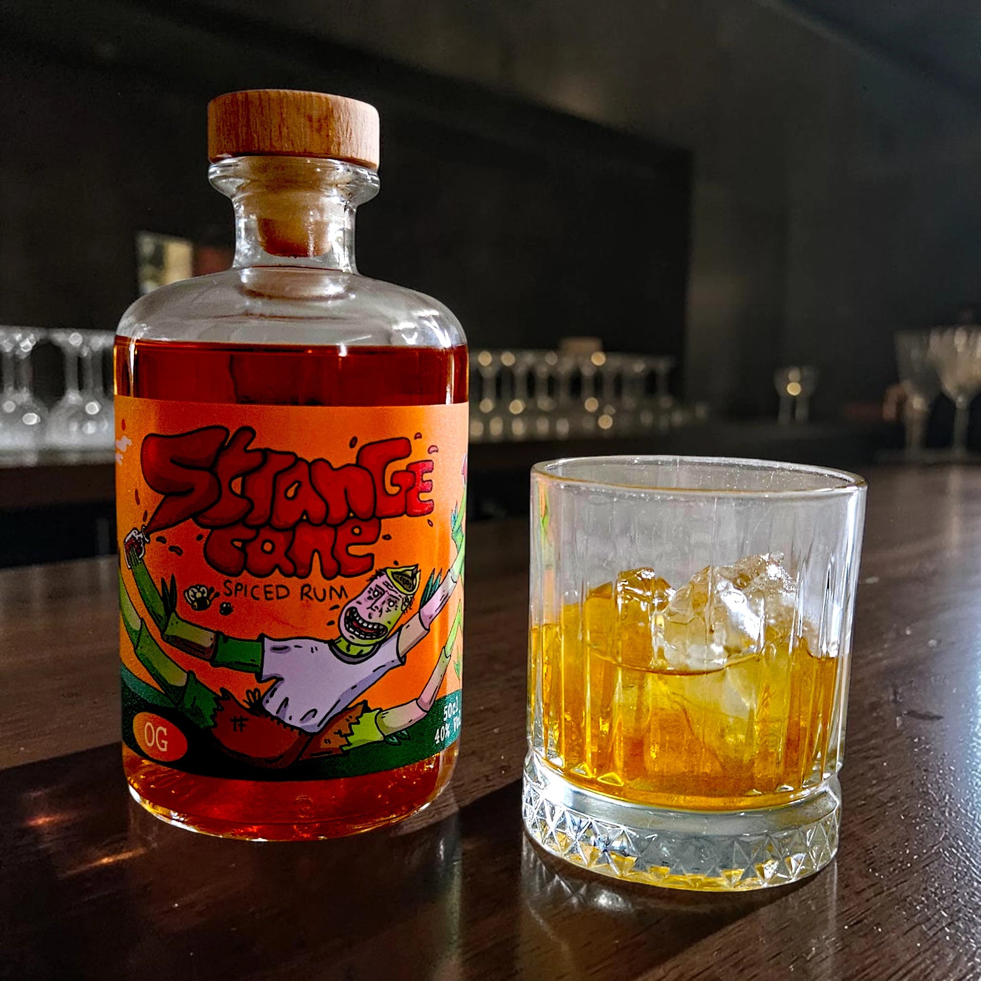 The OG Strange Cane spiced rum bottle with glass served on ice