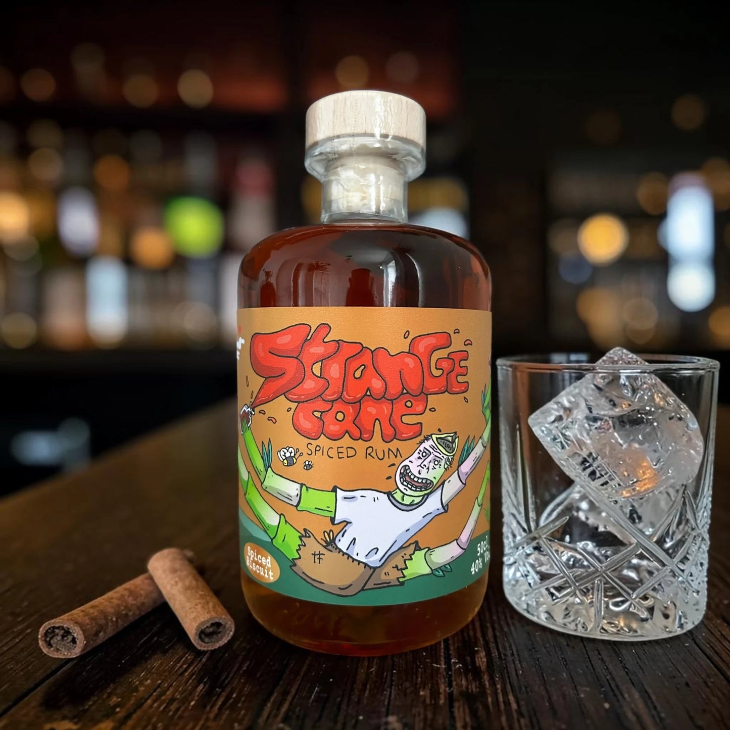 Strange Cane Spiced Biscuit spiced rum with glass and ice, and fresh cinnamon sticks
